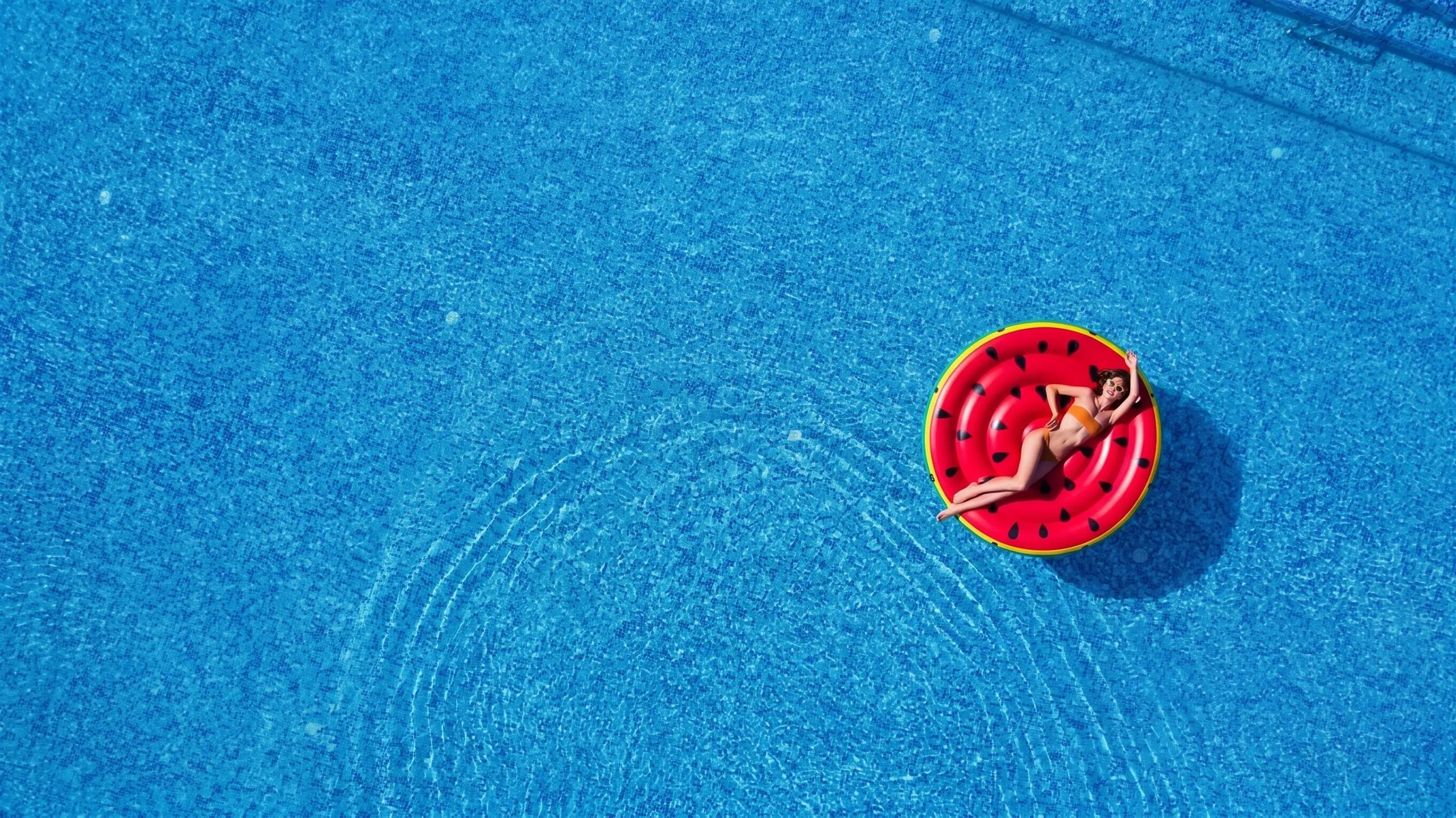 Piscina de agua cristalina con un flotador rojo en forma de sandía